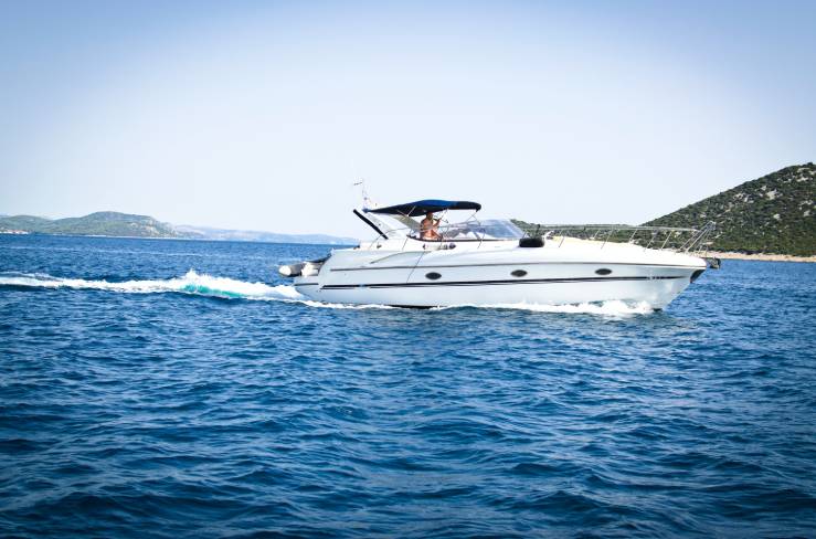 A boat is sailing in the ocean on clear day.